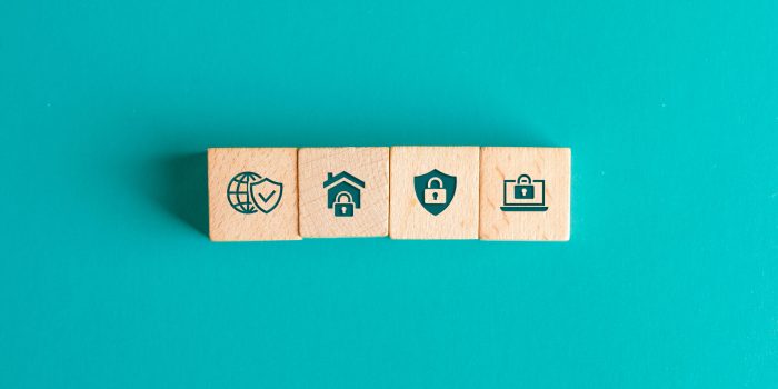 Security concept with icons on wooden blocks on turquoise background flat lay.